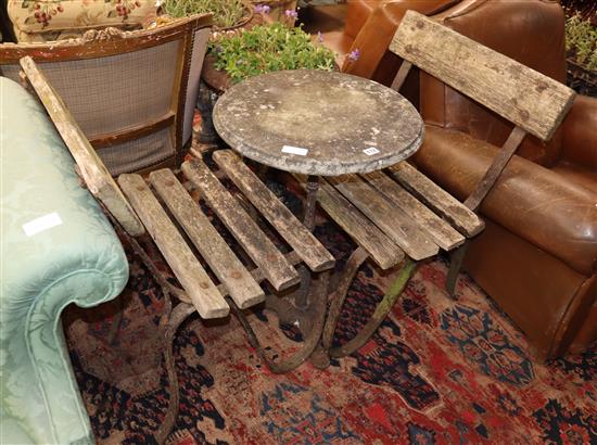 A circular marble topped and wrought iron garden table, together with two slatted garden chairs, Diam.49cm